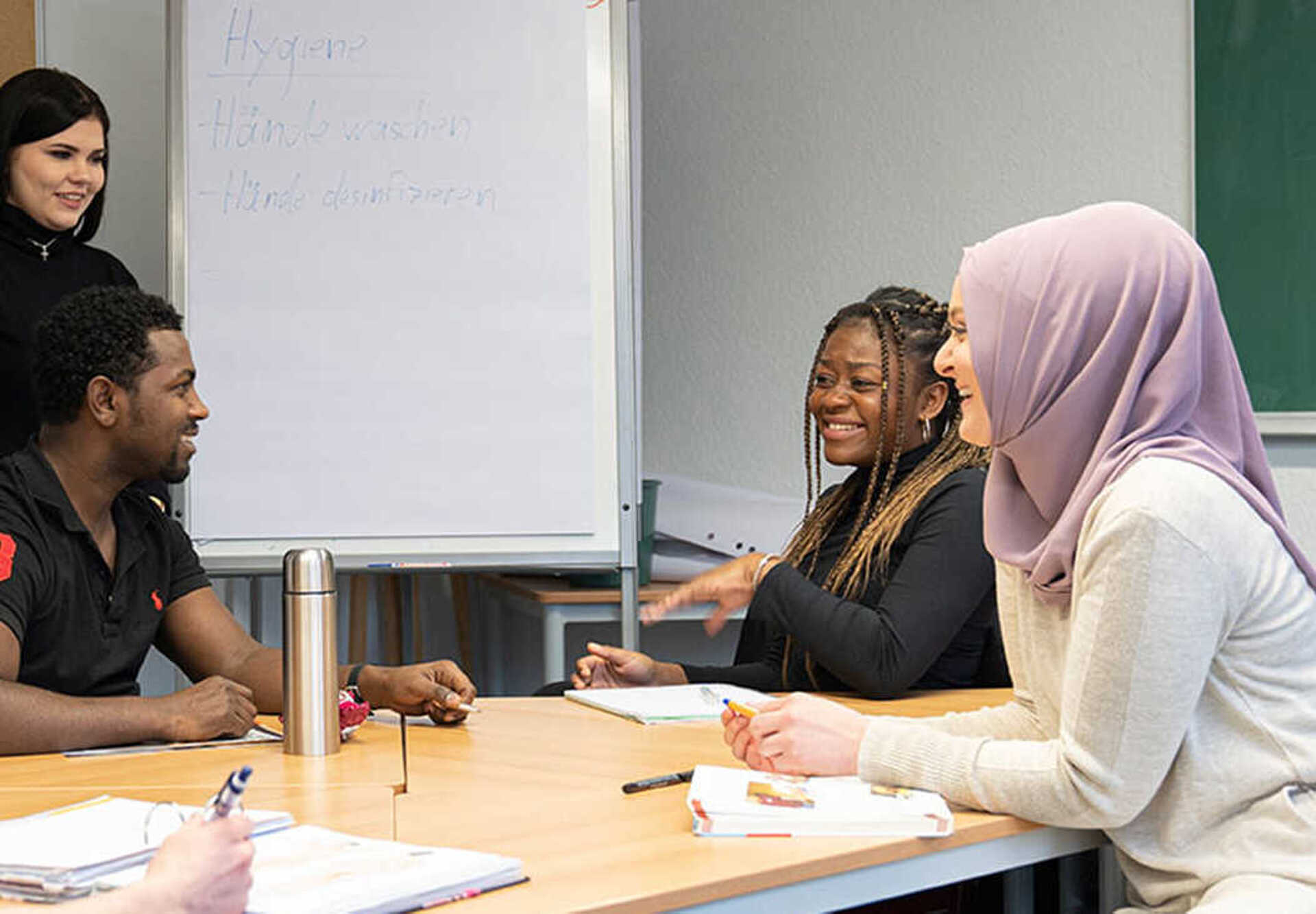 Gesprächssituation Besprechungsraum Fünf Personen sind um einen Besprechungstisch versammelt